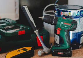 Maintenance image showing a drill, paint, hammer, and other tools.